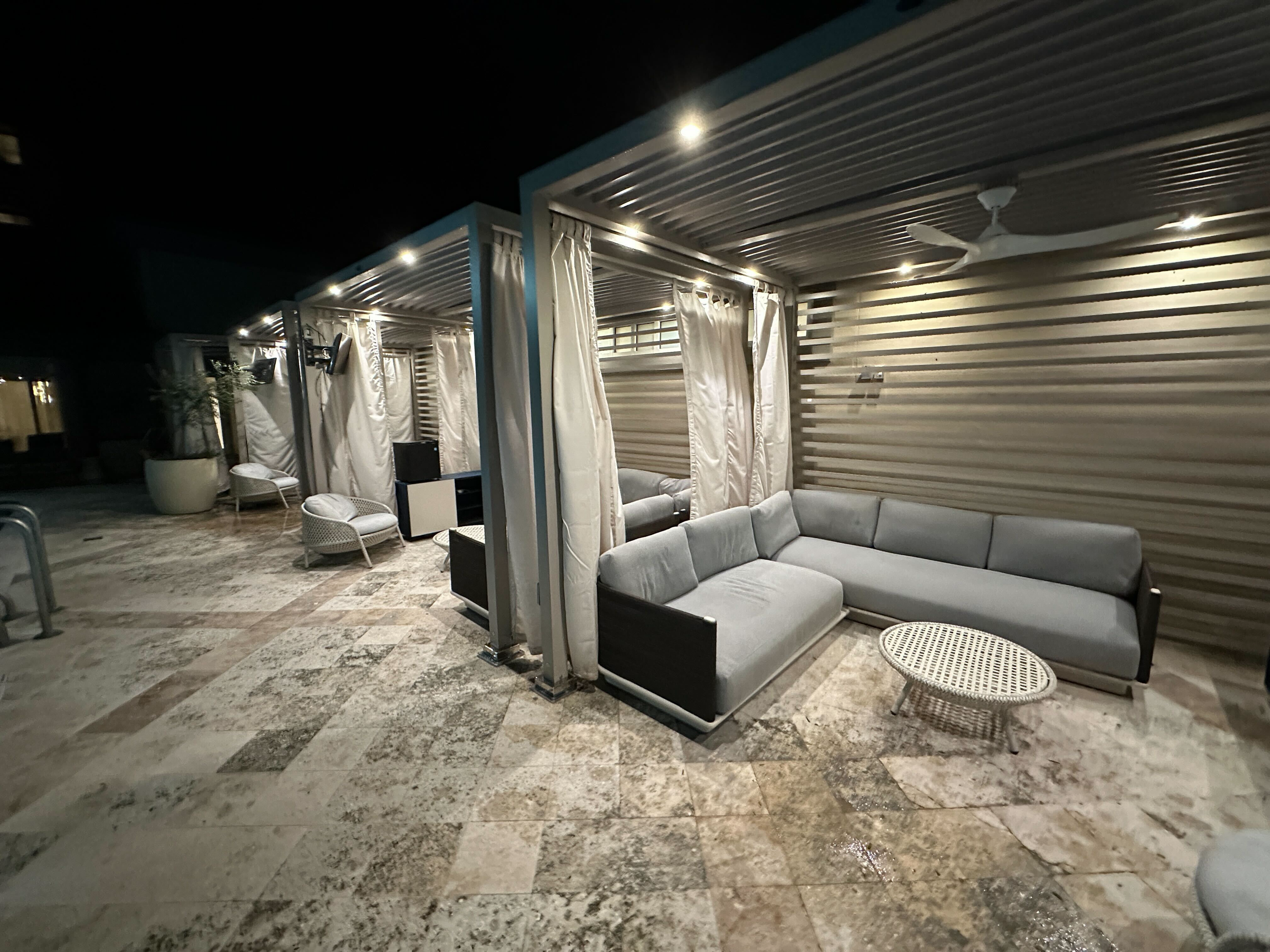 Three VIP cabanas exterior — travertine deck at night