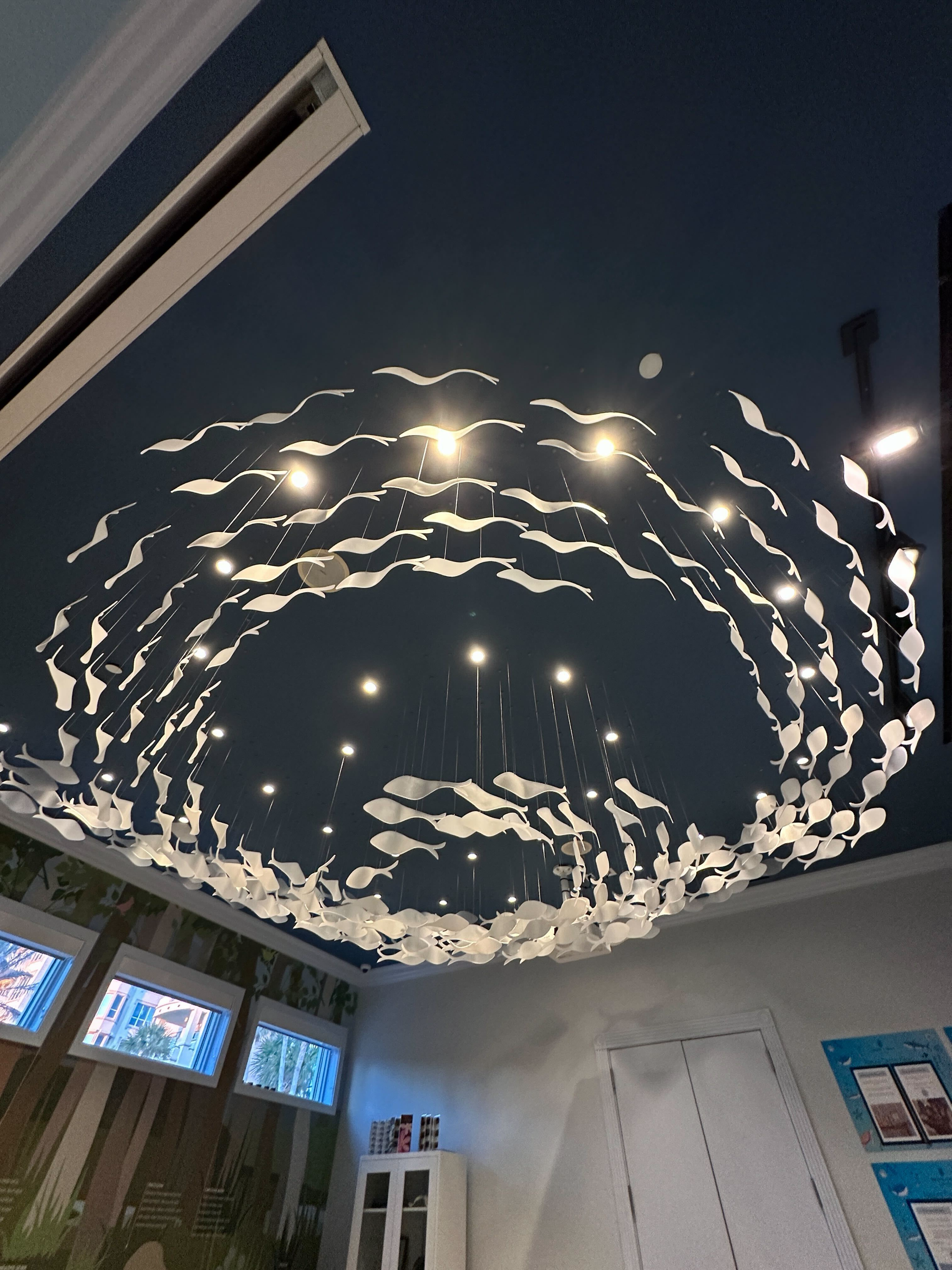Ceiling close-up — sculptural fish elements with recessed lighting