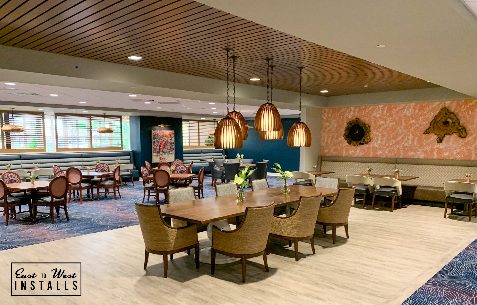 Main dining room with pendant lights and teal banquettes