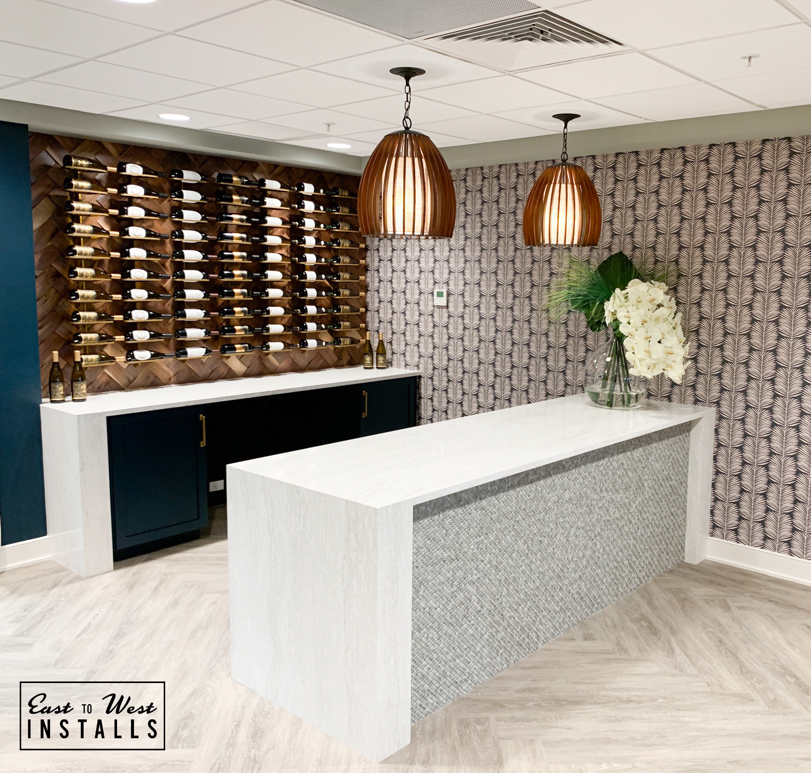 Wine bar and reception area with herringbone wood and copper pendants